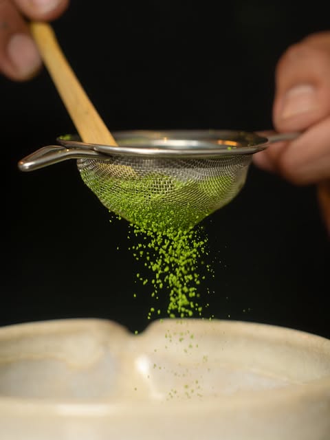 Matcha de primera cosecha cayendo de un tamiz